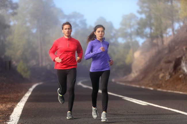 Healthy running runner man and woman workout on mountain road. J